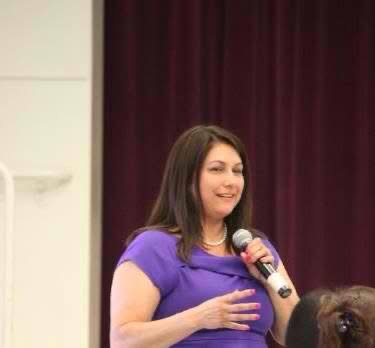Kathryn speaking into a microphone at an education event